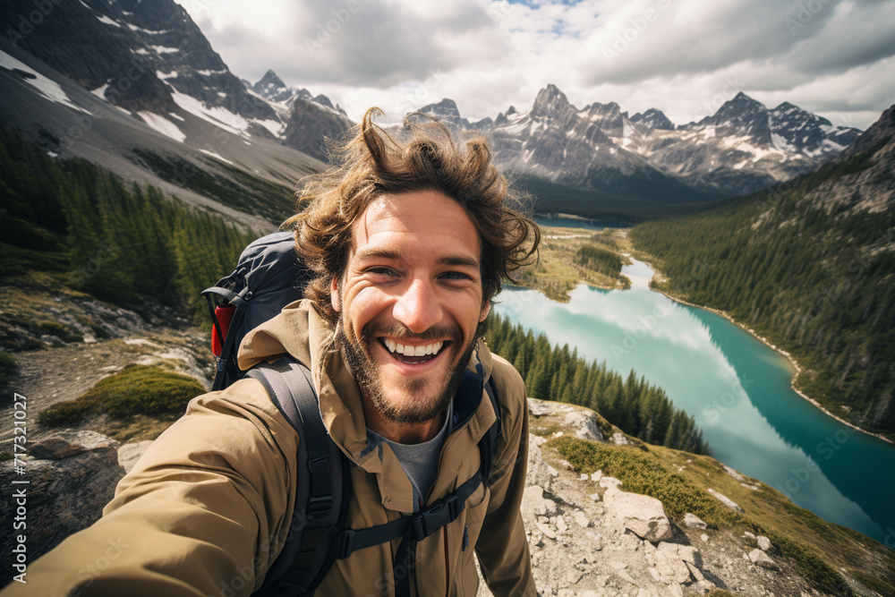 On a hiking trail, a guy takes a selfie with scenic mountain views, showcasing both his outdoor adventure and the breathtaking natural surroundings. On a hiking trail, a guy takes a selfie with scenic mountain views, showcasing both his outdoor adventure and the breathtaking natural surroundings.
