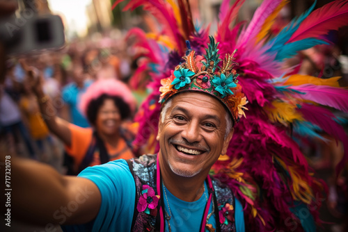 A guy takes a selfie during a vibrant street parade, surrounded by colorful floats, costumes, and lively festivities, capturing the energy of the moment.