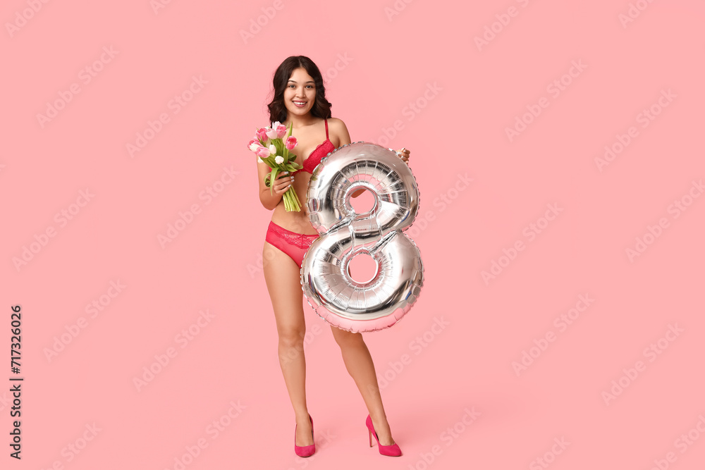 Beautiful young happy Asian woman with tulips bouquet and balloon in shape of figure 8 wearing sexy lingerie on pink background. International Women's Day - obrazy, fototapety, plakaty 