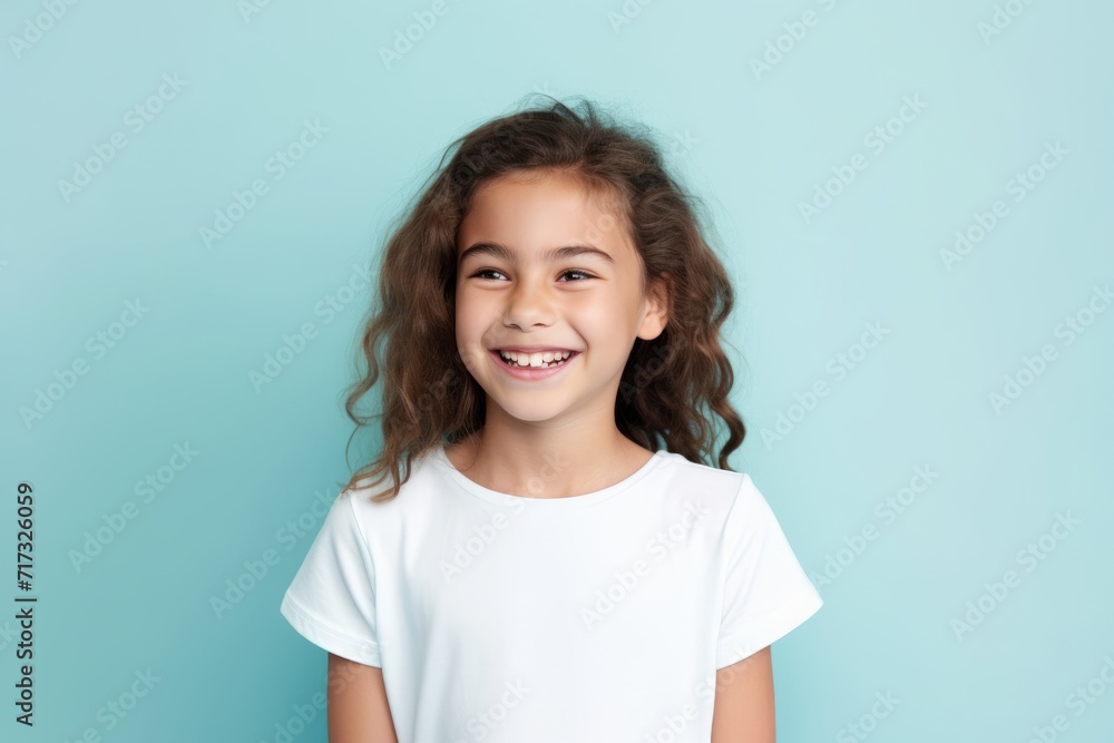Portrait of a cute little girl in a white T-shirt on a blue background Portrait of a cute little girl in a white T-shirt on a blue background