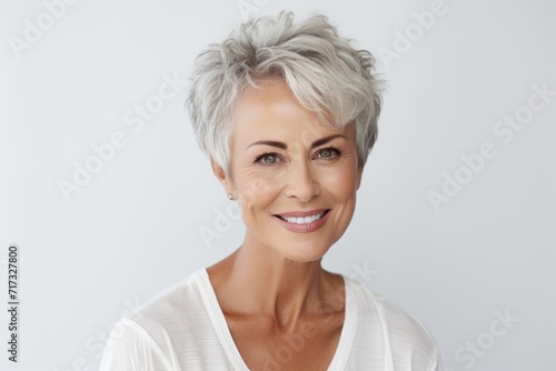 Portrait of beautiful middle-aged woman with grey hair smiling at camera