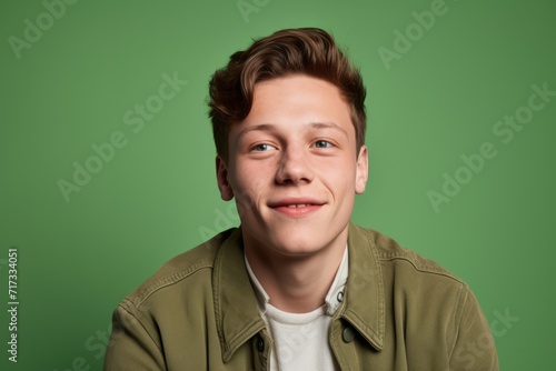 Portrait of a handsome young man looking at camera over green background