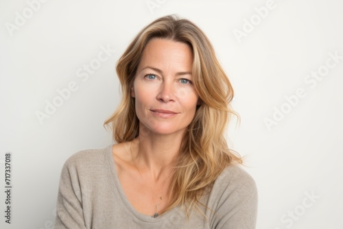 Portrait of a beautiful middle aged woman with long blond hair on a white background