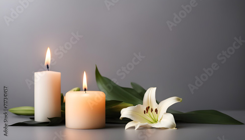 Beautiful lily and burning candle on dark background.