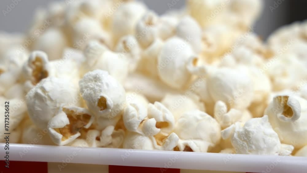 Video showcases perfect treat in cardboard box for great time. Person spends delightful and entertaining evening with bucket of popcorn extreme closeup Video showcases perfect treat in cardboard box for great time. Person spends delightful and entertaining evening with bucket of popcorn extreme closeup