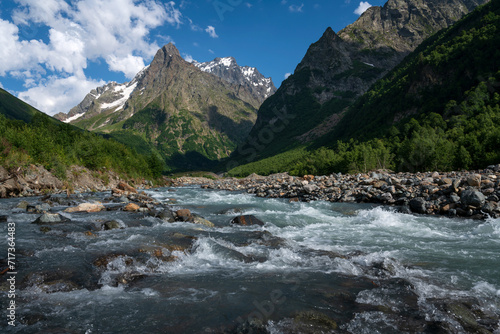View of the Dombay-Ulgen gorge in the mountains of the North Caucasus near the village of Dombay on a sunny summer day, Karachay-Cherkessia, Russia © Ula Ulachka