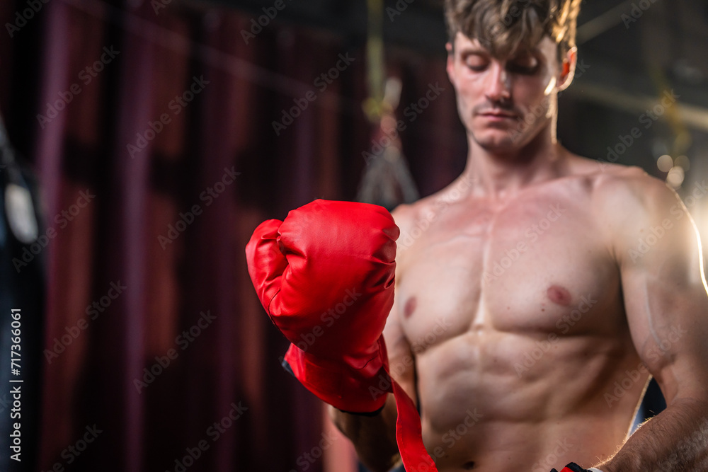 Fototapeta premium Caucasian professional boxer wearing gloves before competition in gym. 