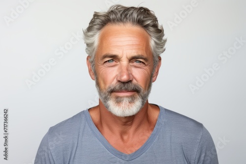 Portrait of mature man with grey hair and beard looking at camera