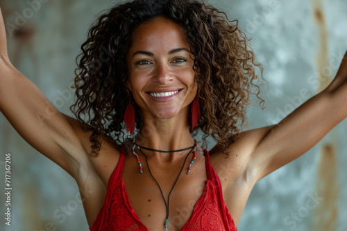 Healthy Joyful Woman with Curly Hair Wearing a Striking Red Top and a Bright Smile - Expression of Happiness and Confidence