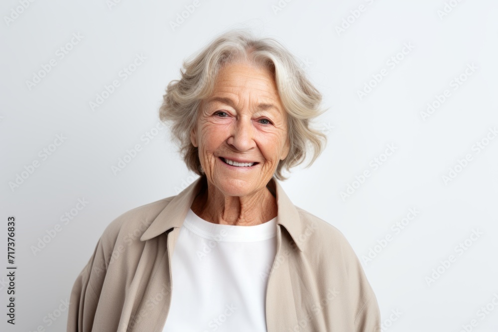 Portrait of a happy senior woman on grey background. Looking at camera. Portrait of a happy senior woman on grey background. Looking at camera.