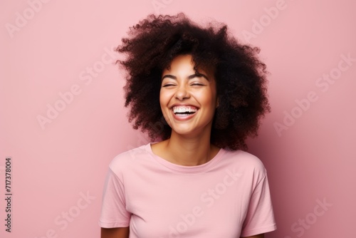 Happy african american woman with afro hairstyle on pink background