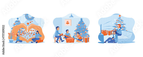 Family sharing Christmas Eve. Three little children opening Christmas presents together under the Christmas tree. Two female friends sitting together near the Christmas tree. 