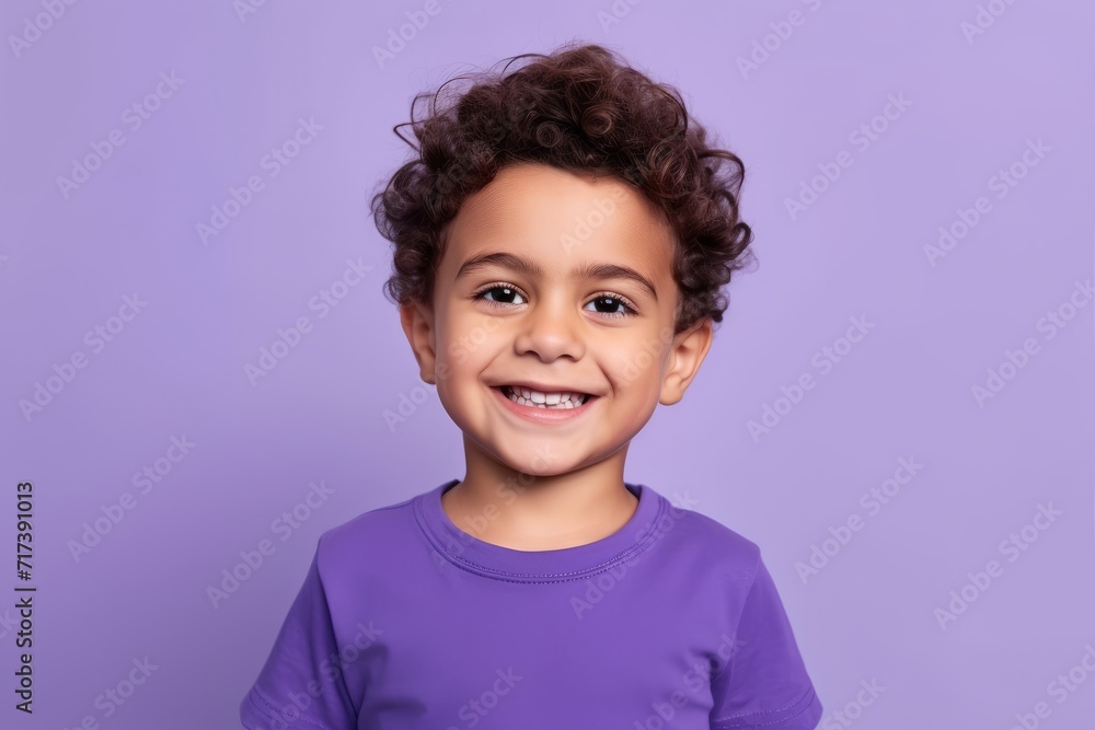Portrait of a cute little girl with curly hair looking at camera and smiling, isolated over purple background Portrait of a cute little girl with curly hair looking at camera and smiling, isolated over purple background