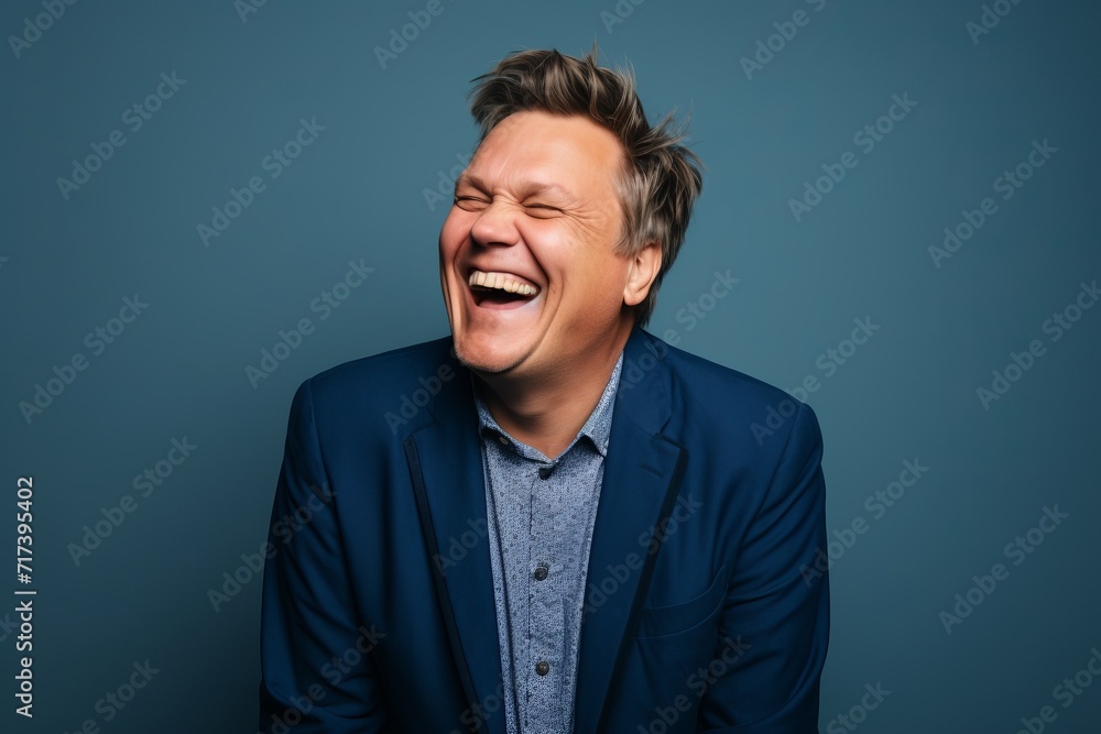 Portrait of a man laughing with closed eyes on a blue background Portrait of a man laughing with closed eyes on a blue background