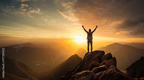 Happy man raising his arms jumping to the top of the mountain, successful businessman celebrating success on the cliff, business success concept silhouette backlit. photo