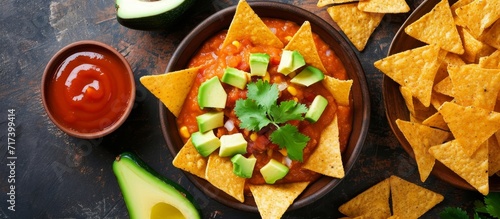 Popular Tex Mex or Mexican appetizer with melted cheeses, spices, hot sauce, homemade tortilla chips, avocado, and meat. photo