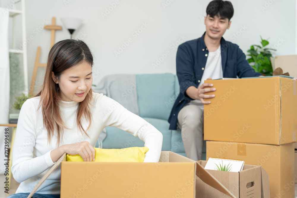 Moving house, relocation. Couple help set and move furniture for new apartment, inside the room was a cardboard box contain personal belongings. move in the new apartment or condominium Moving house, relocation. Couple help set and move furniture for new apartment, inside the room was a cardboard box contain personal belongings. move in the new apartment or condominium