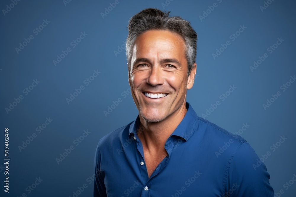 Portrait of a handsome middle-aged man smiling against blue background Portrait of a handsome middle-aged man smiling against blue background