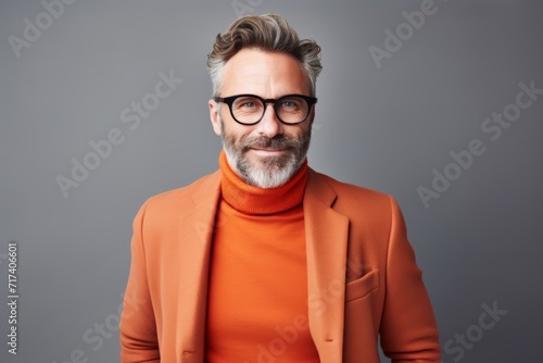 Handsome mature man in orange coat and eyeglasses.