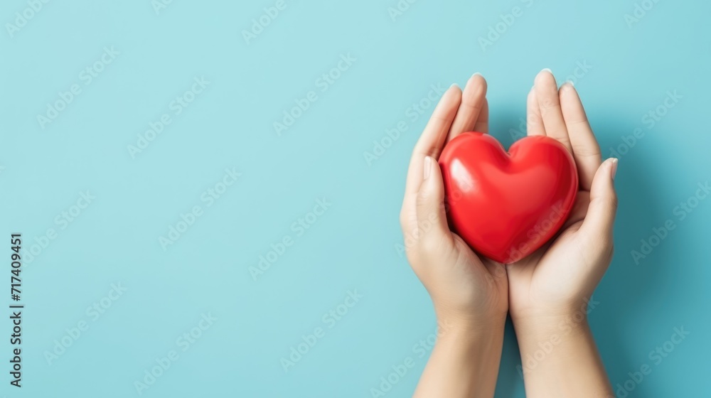 Hands holding red heart on blue background. St Valentine's Day vibe. Hands holding red heart on blue background. St Valentine's Day vibe.