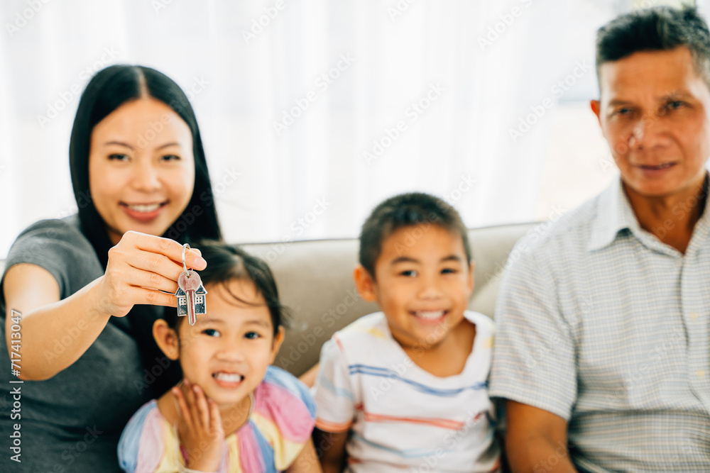 A happy family celebrates new homeownership mother proudly holding keys to their house. The image captures familial joy excitement and the promise of a new living space. New house A happy family celebrates new homeownership mother proudly holding keys to their house. The image captures familial joy excitement and the promise of a new living space. New house