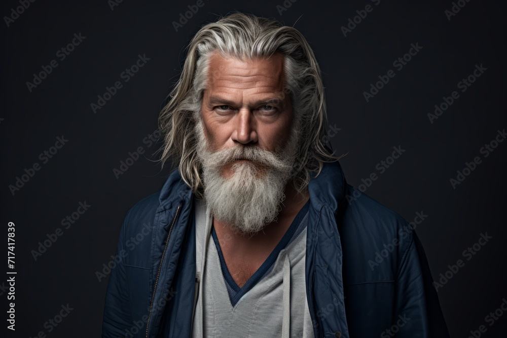 Portrait of an old man with long gray hair and beard. Isolated on black background.