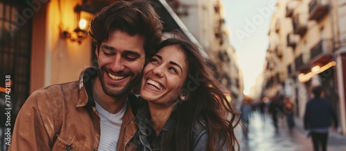 Young couple happily smiling outdoors near a hotel.