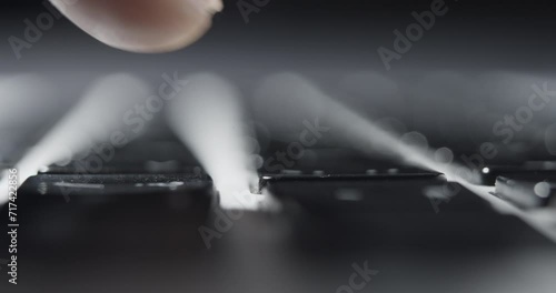Extreme Close-up of Fingertip Pressing Single Key on Laptop Keyboard