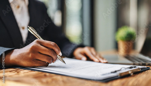 black woman signing insurance agreement during a meeting with agent, symbolizing trust, security, and financial empowerment