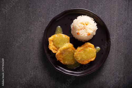 Cutlets of shredded chicken meat fried in batter egg, in Mexico known as Tortitas de Pollo, bathed with green sauce and accompanied by rice. Traditional and very popular homemade recipe in Mexico.