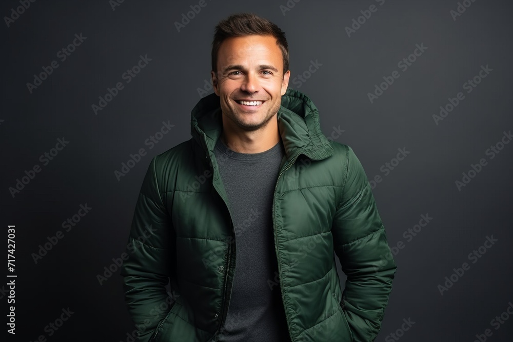 Portrait of a handsome smiling man in a green jacket on a dark background Portrait of a handsome smiling man in a green jacket on a dark background