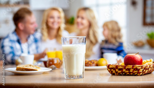 Happy family having breakfast at home. Focus on the glass of milk