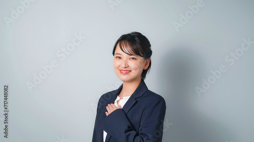 胸に手を当てるビジネススーツを着た女性 photo