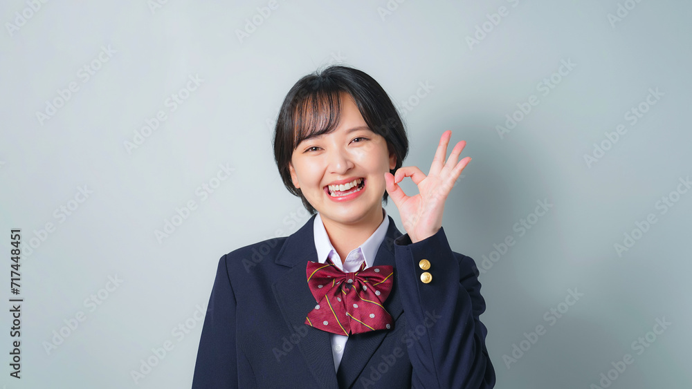 OKサインを見せる制服を着た女子学生