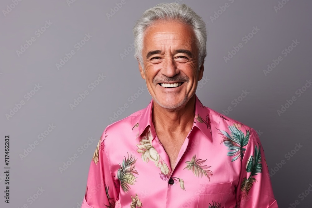 Portrait of a happy senior man in pink shirt on grey background Portrait of a happy senior man in pink shirt on grey background