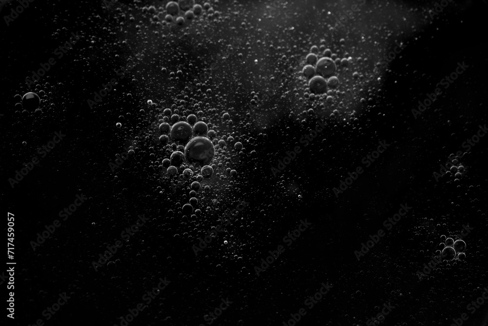 Obraz premium Air bubbles in the water background.Abstract oxygen bubbles in the sea.Water bubbles isolate on black background.Black and white tone style.