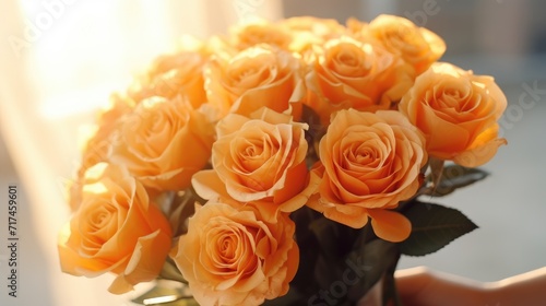 A bouquet of yellow  orange roses in women s hands for congratulations on Mother s Day  Valentine s Day  Women s Day. Blurred background.
