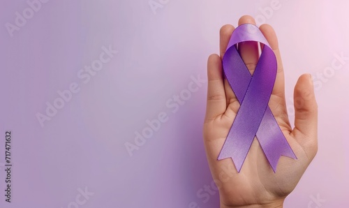 health and treatment concept - womand hand holding purple cancer awareness ribbon.