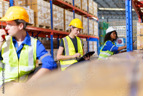 The warehouse officer, who is female, is presently conducting an inspection of the inventory within the warehouse. photo