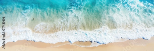 Aerial view of ocean waves washing ashore, capturing the dynamic interface of land and sea.