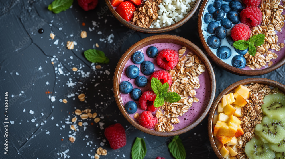 Smoothie bowl with fresh fruit and granola on top. Multiple varieties, top down view. Smoothie bowl with fresh fruit and granola on top. Multiple varieties, top down view.