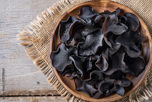 Wooden plate with dried jelly ear black mushrooms Auricularia auricula judae flat lay or top view