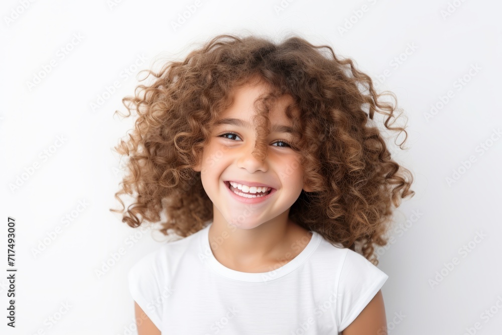 Close-up portrait of a smiling little girl with curly hair on a white background Close-up portrait of a smiling little girl with curly hair on a white background