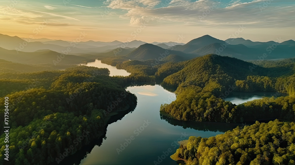 Beautiful landscape of green mountains and lake in the morning with sunrise sky. Nature landscape. Watershed forest. Water and forest sustainability concept. Aerial view of mountain with green trees