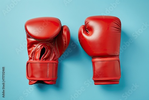 Red boxing gloves on colored background seen from above