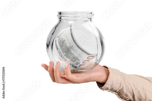 A businessman shows a glass jar filled with dollar cash bills