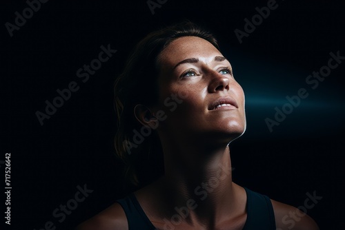 Portrait of a young woman in sportswear on dark background