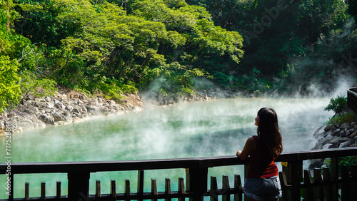 Hot spring water at Beitou Thermal Valley or Geothermal Valley, Taiwan. Woman traveler looking at Hot spring pond at Xinbeitou thermal valley in Taiwan. photo