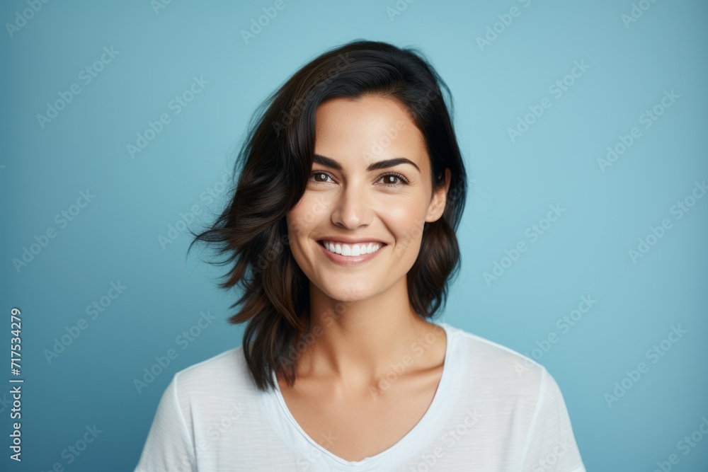 Portrait of smiling young woman in white t-shirt on blue background Portrait of smiling young woman in white t-shirt on blue background