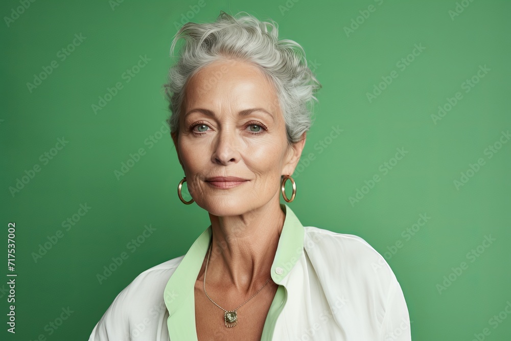 Portrait of a beautiful senior woman with grey hair on a green background Portrait of a beautiful senior woman with grey hair on a green background
